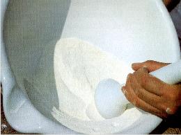 Pulverisieren des Milchpulvers in Porzellanschssel mit Porzellanmrser